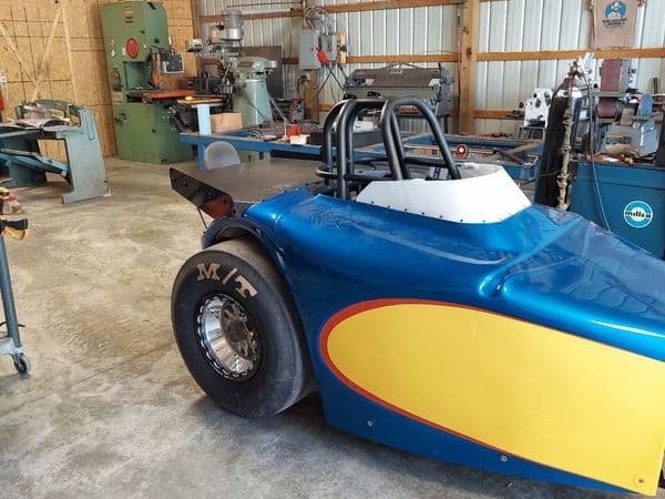 Blue and yellow custom dragster in workshop